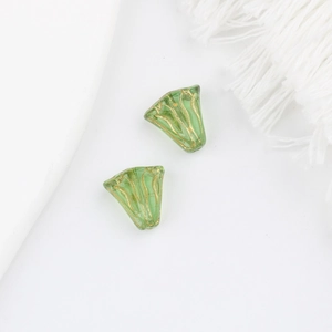Macro-opname van groene Tsjechische glazen bloemkralen met goudkleurige nerven voor DIY-sieraden