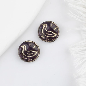 Macro detail of dark purple Czech glass beads with gold bird pattern and vintage finish