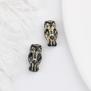 Detailed view of vintage black owl beads with intricate gold engraving for DIY crafts