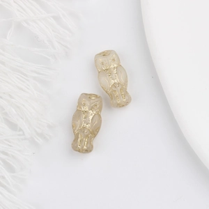 Detailed macro view of vintage Czech glass owl beads with gold gilded accents for DIY jewelry