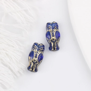 Macro detail of royal blue owl glass beads with gold accents for DIY jewelry making