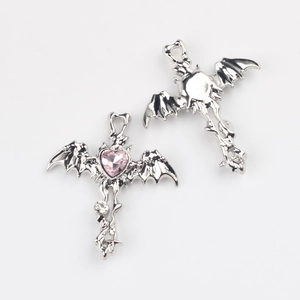 Detailed view of silver bat wing cross charms with pink heart zircon for DIY jewelry