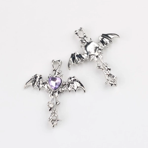 Detailed view of silver gothic bat cross pendant with purple heart zircon and white stones