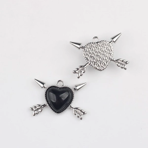 Detail of alloy heart and arrow pendant with black resin inlay for jewelry DIY
