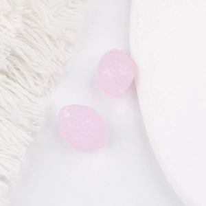Détail macro de deux perles en résine rose mat pour la fabrication de bijoux DIY