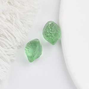 Gros plan de deux perles en verre vert en forme de citron pour création de bijoux DIY