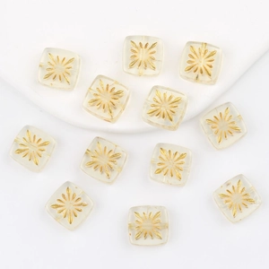 Macro detail of square clear glass beads with gold fireworks pattern for DIY jewelry