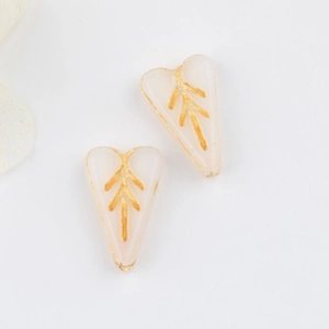 Detail of pink heart-shaped glass beads with vintage gold leaf pattern for DIY jewelry