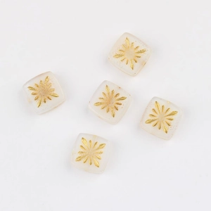 Macro shot of 10mm square glass beads with hand-painted gold fireworks pattern for DIY jewelry