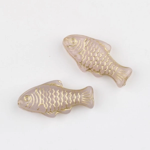Close-up of lavender glass fish beads with gold-painted scales for DIY jewelry making
