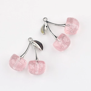 Detail of pink resin cherry pendants with glitter and silver leaves for DIY jewelry making