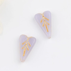 Close-up of lavender heart-shaped glass beads with vintage gold leaf vein patterns