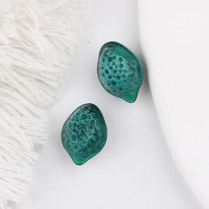 Vue détaillée de perles en verre vert foncé texturées pour la création de bijoux artisanaux
