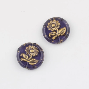 Macro shot of two purple glass sunflower beads with gold detailing for DIY jewelry