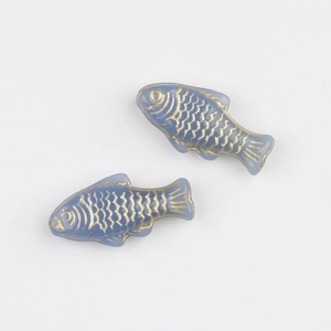 Macro detail of two light blue glass fish beads with hand-painted gold leaf scales