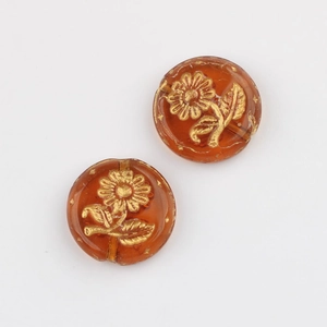 Detailed view of amber Czech glass beads with hand-painted gold sunflower patterns