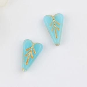 Macro view of blue crackle glass heart beads with gold leaf patterns for DIY jewelry