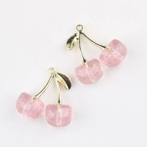 Detailed view of pink translucent resin cherry pendants with glitter and gold stems