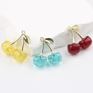 Glittering resin cherry pendants in yellow, blue and red with gold metal leaf for DIY