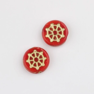 Detailed macro of red Czech glass beads featuring gold-painted spider web wheel patterns