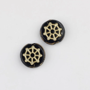 Macro detail of hand-painted black and gold spiderweb pattern glass beads for DIY jewelry