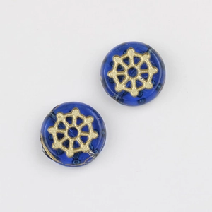 Detailed view of two blue glass beads with gold painted spider web patterns for DIY jewelry