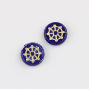 Macro detail of blue Czech glass spiderweb beads with gold hand-painted patterns