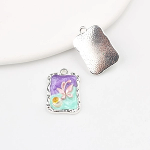 Detail of enamel flower pendants showing front floral design and silver textured back