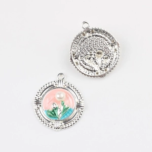 Macro detail of enamel flower pendants with small pearl in silver-tone metal finish