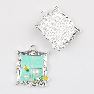 Close-up of mint green alloy pendant with faux pearls and leaf details for DIY jewelry
