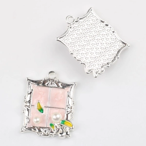 Macro detail of alloy frame pendant with pink resin, faux pearls and enamel leaves