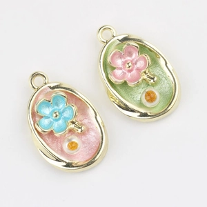 Close-up of floral enamel pendants with faux pearls for DIY bracelet jewelry making