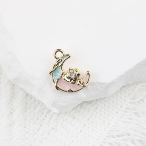 Vue macro du pendentif lune avec émail rose et bleu et détail de rose en zircon
