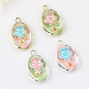 Detailed macro view of Monet Garden alloy pendants with enamel flowers and inset pearls