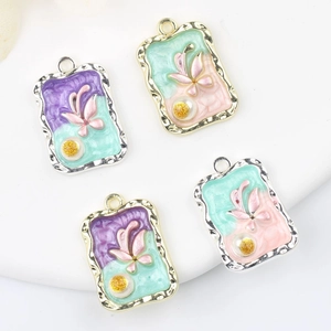 Macro detail of rectangle butterfly pendants with colorful oil drip and pearl inlays