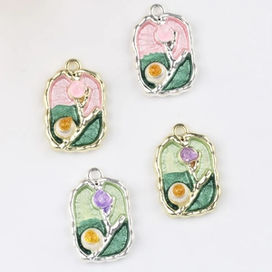 Macro detail of enamel flower pendants with wave patterns and embedded crystals