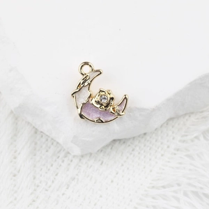 Vue macro d'un pendentif lune en alliage doré avec émail violet et zircon incrusté