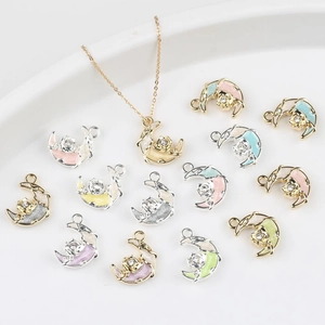 Vue macro de pendentifs lune et rose en émail coloré avec incrustations de zircons