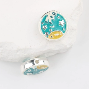 Macro shot of silver enamel astronaut space charms on white textured stone for DIY jewelry