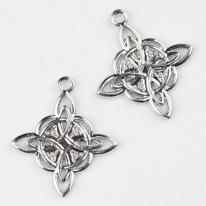 Macro view of silver Celtic knot charms with intricate textures and top hanging rings