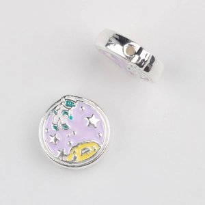 Macro detail of purple enamel astronaut beads showing the central hole for DIY jewelry