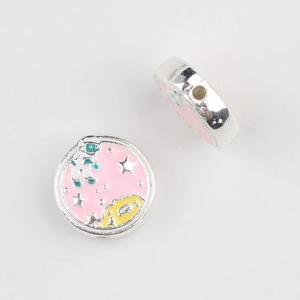 Detail of silver alloy spacer beads featuring pink enamel astronaut and star patterns