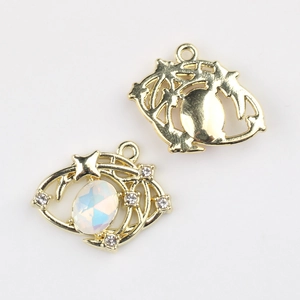 Detail eines vergoldeten Augenanhängers mit weißem Opal-Inlay und hohler Metallrückseite