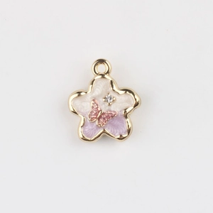 Detail of flower charm with purple enamel gradient, pink butterfly, and rhinestone inlay