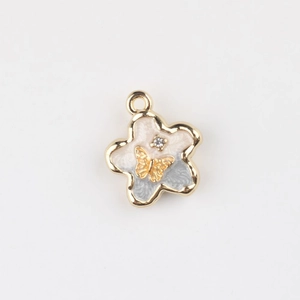 Detailed macro of flower pendant with enamel petals, gold butterfly, and zircon inlay