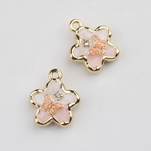 Macro view of flower pendants with enamel inlay and butterfly detail for DIY jewelry
