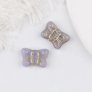 Macro detail of purple vintage Czech glass butterfly beads with gold gilded edges