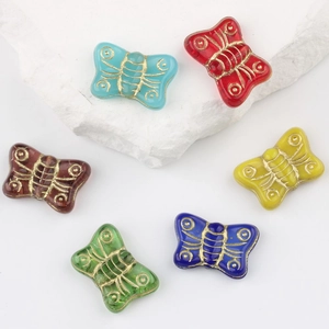 Detailed view of six colorful vintage glass butterfly beads with golden edge textures