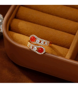 Detailed view of snake-shaped gold ring with red agate and sparkling cubic zirconia
