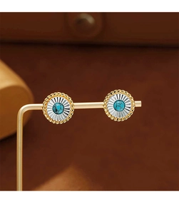 Gros plan de boucles d'oreilles fleur vintage avec incrustation turquoise et motifs dorés